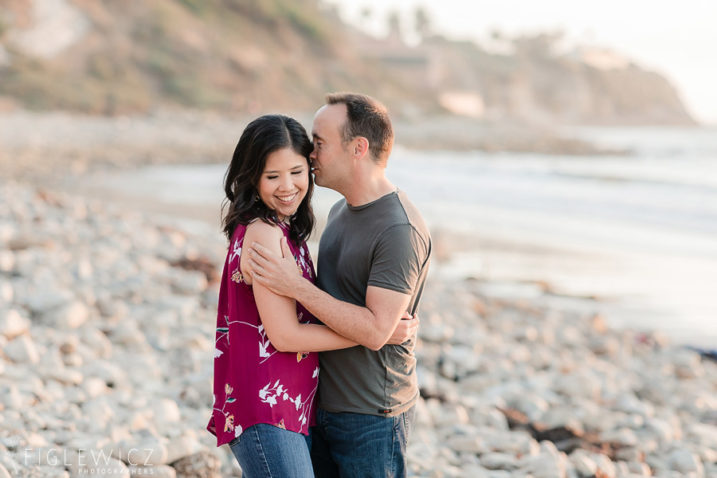 engaged couple embracing on the beach