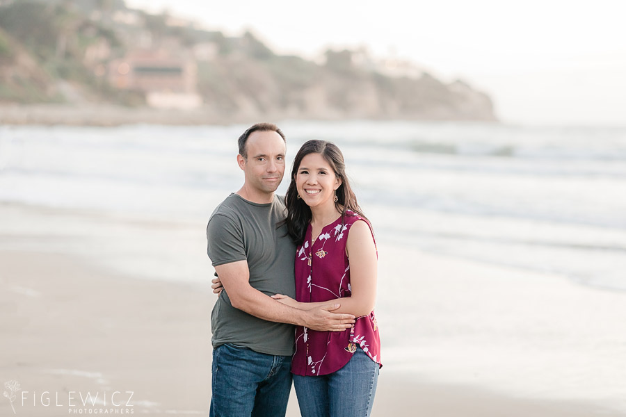 engaged couple embracing on the beach